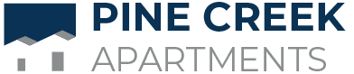 The blue and grey logo of Pine Creek Apartments in Houston